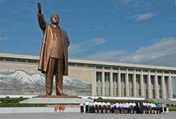 People bowing to leaders sixty-foot statue.